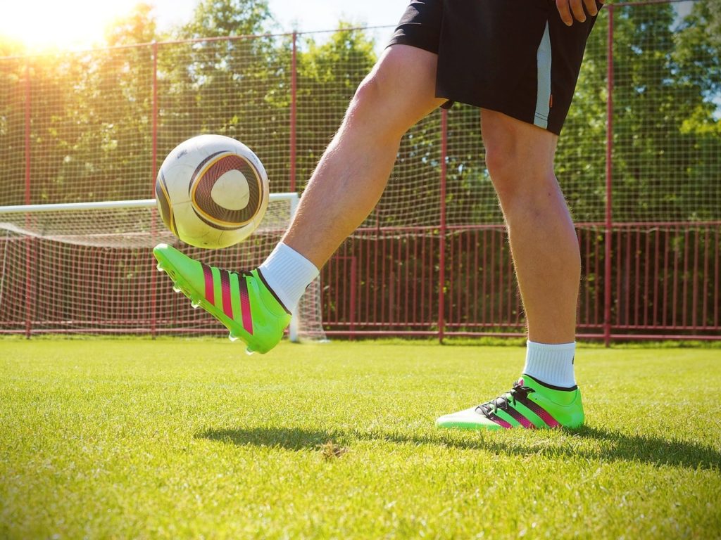 A soccer player kicking a soccer ball.