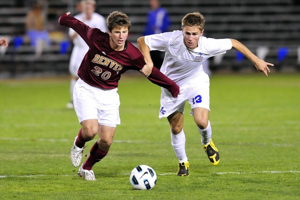 Two college soccer players using a Nike soccer ball.